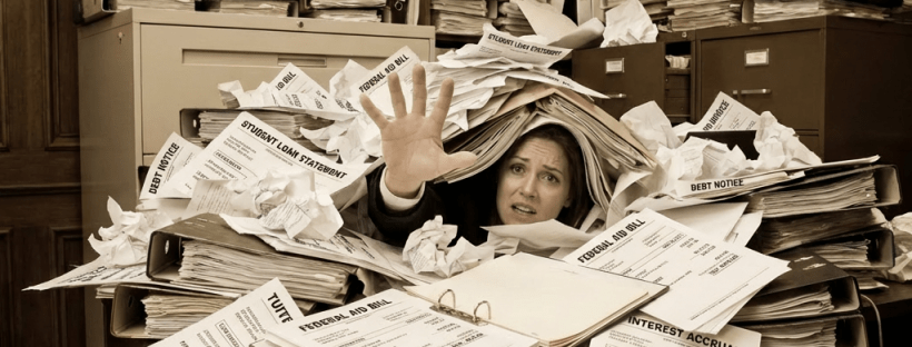 A man buried under a massive pile of office paperwork reaches out for help.